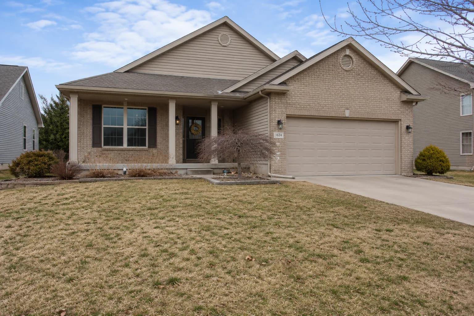 Front yard with a dry, brown and patchy lawn